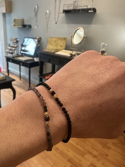 Ce bracelet monté sur élastique, est facile à enfiler et à retirer, au gré de vos envies.  Assortiment délégant de pierres naturelles et de laiton doré à l'or fin 2 microns 24 carats Il convient à un poignet de 16 cm avec sa taille standard de 16.5 cm. Existe en deux couleurs, onyx noir ou quartz fumé. Une création française.