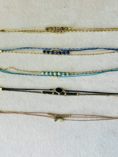 Bracelet composé d'un assortiment de cordons, de pierres, et une fine chaîne dorée 2 microns. Longueur de 15 à18 cm, grâce à la rallonge, mousqueton. Atelier Nîmois.
